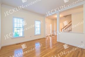 Glen Allen house for rent - a large living room with hardwood floors and a staircase in the background