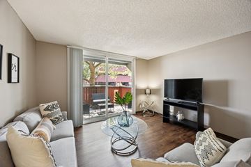 Reno apartment for rent - A living room with a grey couch and a glass coffee table.