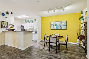 Tampa apartment for rent - Open kitchen and dining area with yellow accent wall at The Arbor Walk Apartments, Tampa, FL 33617