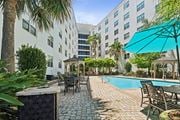 New Orleans apartment for rent - Pool surrounded with table and chairs at Esplanade at City Park, Louisiana, 70119
