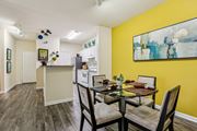 Tampa apartment for rent - Dining area with glass table and modern kitchen at The Arbor Walk Apartments, Tampa, FL