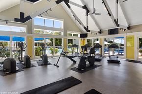 Cincinnati apartment for rent - a gym with exercise equipment and windows with a pool in the background at Brookstone Village, Cincinnati