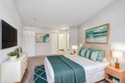 Creve Coeur apartment for rent - A bedroom with a bed, nightstand, and a painting on the wall. at Millennium at Creve Coeur, Missouri, 63141