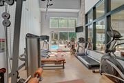 Fort Collins apartment for rent - Gym with exercise equipment and a large window with a pool in the background at Governor's Park, Fort Collins, 80525