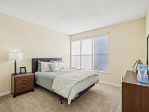 Raleigh apartment for rent - A bedroom with a bed, nightstand, and window. at Cedar Springs Apartments, Raleigh, NC, 27609