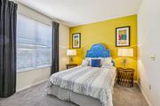 Tampa apartment for rent - Guest bedroom with blue headboard and yellow accent wall at The Arbor Walk Apartments, Tampa, FL 33617