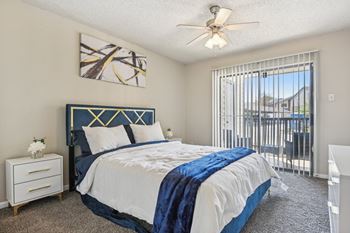 A bedroom with a bed, nightstand, and a ceiling fan