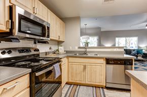 Phoenix apartment for rent - A kitchen with wooden cabinets and stainless steel appliances at Sweetwater At Metro North Apartments, Phoenix, Arizona