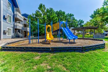 A playground with a blue slide and yellow slide.