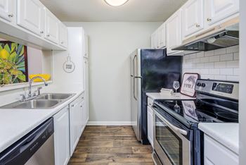 A kitchen with white cabinets and black appliances
