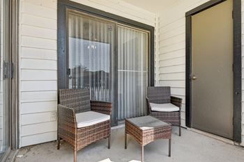 Two chairs and a table are on a porch