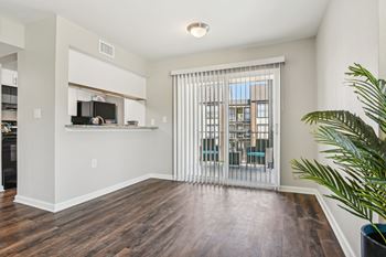 A living room with a wooden floor and a sliding glass door