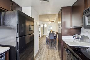 Mesa apartment for rent - A kitchen with a black refrigerator and brown cabinets at Del Coronado Apartment , Arizona, 85202