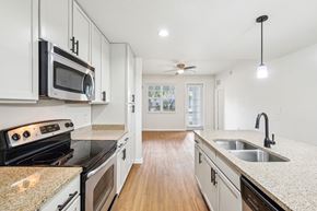 Jupiter apartment for rent - A kitchen with white cabinets and a granite countertop. at The Dakota, Florida