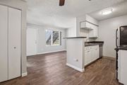 Colorado Springs apartment for rent - A kitchen with white cabinets and a wooden floor. at Windmill Apartments, Colorado Springs, Colorado