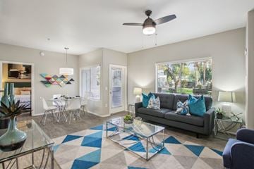 Phoenix apartment for rent - A living room with a grey couch and a glass coffee table.