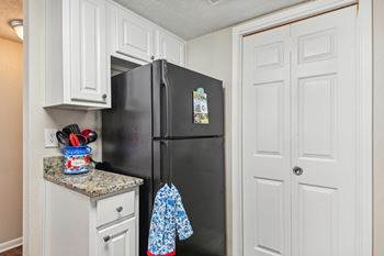 A black refrigerator with a blue and white shirt hanging on it