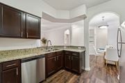Kingwood apartment for rent - A kitchen with dark brown cabinets and granite countertops.at Kingwood Glen, Kingwood, 77339