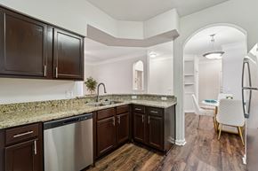 Kingwood apartment for rent - A kitchen with dark brown cabinets and granite countertops.at Kingwood Glen, Kingwood, 77339