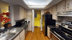 Cincinnati apartment for rent - a kitchen with white cabinets and black appliances and a yellow door at Brookstone Village, Cincinnati