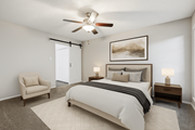 Dallas apartment for rent - A bedroom with a large bed, a chair, and a ceiling fan at The Willows on Rosemeade, Dallas, TX 75287