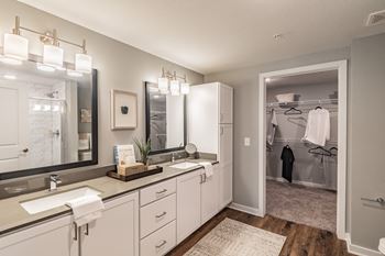 Master bathroom with framed vanity mirrors and closet