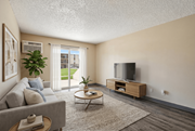 Colorado Springs apartment for rent - A living room with a grey couch, a wooden coffee table, a flat screen TV and a plant at Broadmoor Springs, Colorado Springs, CO, 80906