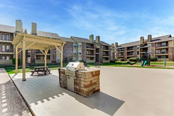 A sunny day at a residential complex with a playground and a picnic table
