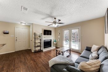 A living room with a grey couch and a fireplace