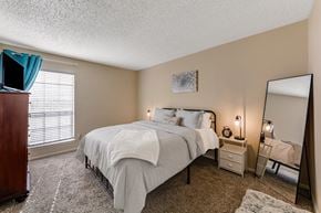Lewisville apartment for rent - a bedroom with a bed and a dresser and a mirror at The Glen Apartments, Texas, 75067