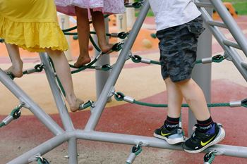 Group of children standing on playground equipment