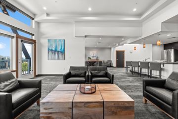 University Place apartment for rent - A modern living room with a large wooden coffee table and black leather chairs.