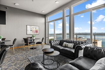 Tacoma apartment for rent - a living room with leather couches and a table with chairs and large windows