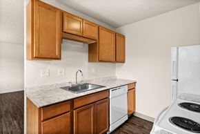 Tumwater apartment for rent - a kitchen with white appliances and wooden cabinets and a sink and counter top