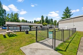 Tumwater apartment for rent - a fenced in area with a picnic table in front of a building