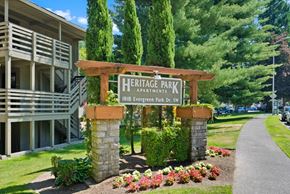 Olympia apartment for rent - a sign for heritage park apartments in front of a sidewalk