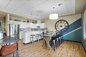 Edgewood apartment for rent - a kitchen with a large clock on the wall and a table with chairs