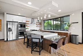 Tacoma apartment for rent - a kitchen with a large island with a white counter top and a stainless steel refrigerator