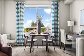 Tacoma apartment for rent - a dining room with blue and white curtains and a table with chairs