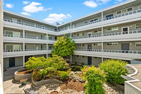 Tacoma apartment for rent - an exterior view of an apartment building with trees in the courtyard