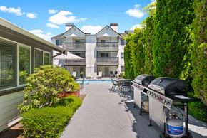 Bremerton apartment for rent - a patio with a grill and a pool in front of a house