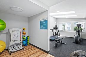 Bremerton apartment for rent - a gym with a treadmill and weights on the floor and a window