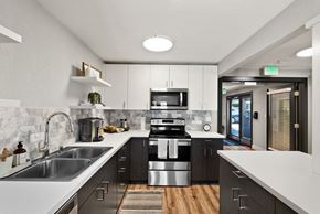 Bremerton apartment for rent - an open kitchen with white counter tops and black and white appliances