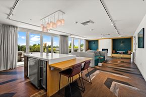 Seattle apartment for rent - A modern kitchen with a large island and a view of the trees outside.