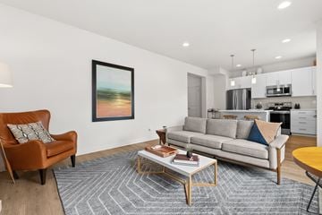 Gig Harbor apartment for rent - A living room with a brown chair, a grey couch, a coffee table, and a painting on the wall.