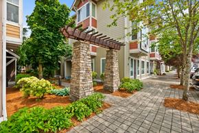 Gig Harbor apartment for rent - a brick sidewalk in front of a building with trees