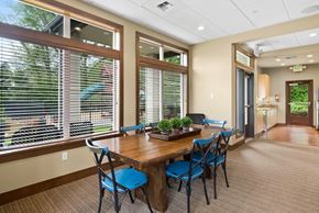 Port Orchard apartment for rent - a dining room with large windows and a wooden table with blue chairs