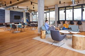 Tacoma apartment for rent - A modern office space with wooden floors and a mix of blue and grey furniture.