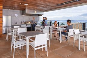 Tacoma apartment for rent - A group of people are gathered around a table in a modern outdoor kitchen.