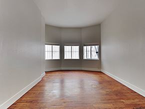 San Francisco apartment for rent - an empty living room with wood floors and three windows